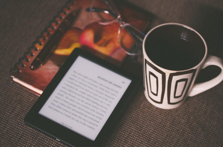 ebook reader beside a mug